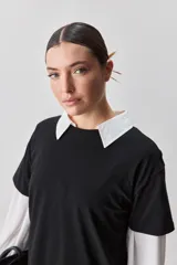 Remera de manga corta negra de algodón, con silueta relajada, cuello redondo y tajos laterales.