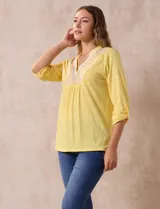 Blusa amarilla de manga 3/4 con escote en V y bordado multicolor. Largo de manga regulable con presilla y botón. Marca Ruby Rd.