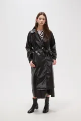 Trinchera de eco-cuero en color bordó, con diseño de doble botonadura, solapas amplias y cinturón ajustable en la cintura. Presenta mangas largas con detalles en los puños y bolsillos laterales.