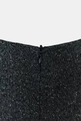 Vestido midi jaspeado en tonos grises, con cuello redondo, manga sisa y bajo en evasé. Incluye un cinturón ancho negro con hebilla rectangular y cierre de cremallera oculta en la espalda.