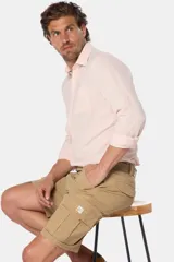 Bermuda cargo color beige con cinturón, confeccionada en tejido de algodón con elasticidad, con bolsillos laterales y detalles en bolsillos traseros con solapa.