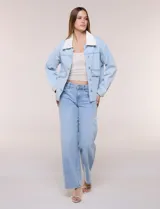 Campera de denim blanco de corte holgado con hombros caídos, cuello con solapa en contraste de color celeste, cierre frontal con botones metálicos y bolsillos delanteros con solapa.
