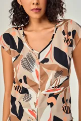 Blusa de poliéster sin mangas, con cuello en V y estampado abstracto multicolor en tonos beige, marrón, negro y naranja.