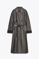 Gabardina larga de efecto encerado en color marrón oscuro, con cuello solapa y cierre frontal cruzado con botones. Presenta mangas largas con puños vueltos en pana, bolsillos laterales y cinturón ajustable de pana. Incluye pinza en la espalda.