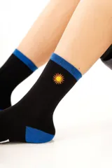 Medias de algodón color crema con detalles en celeste en el puño y talón, presentando un pequeño bordado de sol en el lateral.