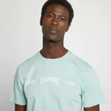 Camiseta de manga corta en color verde agua, con cuello redondo y estampado frontal con texto y números en color blanco.