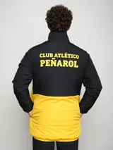Parka negra con detalles en amarillo y escudo del Club Atlético Peñarol en el pecho.