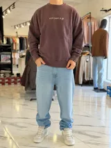 Buzo oversize de cuello redondo en color marrón con efecto gastado, con gran estampado en la espalda de estrellas y el texto VCP CNPT.