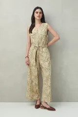 Mono largo sin mangas de algodón con estampado de hojas en tonos verde y beige. Tiene cuello en V, cierre frontal con botones, bolsillos laterales y cinturón de lazo.