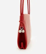 Bolso pequeño tipo bowling de estructura flexible y acabado liso. Cuenta con asa de hombro fija ajustable mediante nudos laterales y cierre magnético.