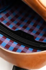 Mochila de diseño combinado en tonos tostado y marrón claro, con detalles en negro y asa superior.