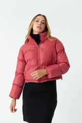 Campera puffer corta color ladrillo, con cuello alto y cierre frontal.