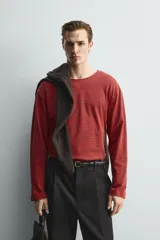 Camiseta de manga larga con cuello redondo, corte relajado y diseño de rayas horizontales en tonos rojo y negro.