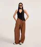 Pantalón wide leg de estilo sastre color marrón, con cintura elástica, lazo ajustable y pliegues frontales. Presenta un corte recto y fluido.