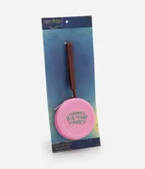 Monedero redondo de silicona color rosado con cierre de cremallera y correa de mano marrón. Presenta un estampado temático en color verde con la frase 'Happee Birthdae Harry'.
