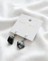 Aros colgantes con aro de acero plateado y dije cuadrado de piedra nacarada en tonos blanco y negro.