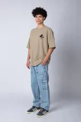 Remera negra de corte oversize confeccionada en algodón pesado, con estampa pequeña de Mickey Mouse en el pecho y diseño gráfico en la espalda.