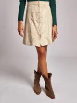 Falda mini color beige, de corte recto, con cierre frontal de botones y confeccionada en poliéster y elastano.