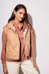 Chaleco acolchado color camel con diseño de rombos. Interior con estampado floral.