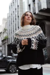 Sweater de lana con diseño de tejido jacquard en la parte superior y mangas, cuello redondo a la base y corte holgado con tajos laterales.