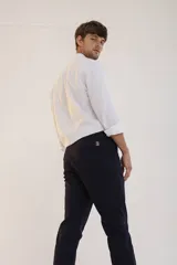 Pantalon de corte recto y ajuste slim, color azul marino, con cierre de botón y cremallera, bolsillos laterales y traseros.