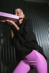 Pantalón largo de ecocuero color lila, con tiro alto, calce ajustado y botamanga irregular.