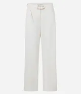 Pantalón de vestir color crudo, de corte recto, con bolsillos laterales y traseros. Se ajusta a la cintura con cinturón de cuero marrón con hebilla dorada.