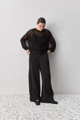 Sweater calado de punto negro, con cuello redondo y mangas largas, de diseño liviano ideal para superposiciones.