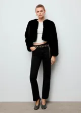 Chaqueta corta de efecto pelo sintético en color negro, con cuello redondo, diseño recto y manga larga.