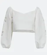 Blusa corta blanca de algodón con escote cuadrado, manga larga abullonada con bordados, y látex en la espalda.