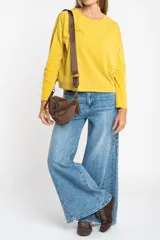 Remera oversize de manga larga color marrón, con cuello redondo y efecto de lavado. Presenta un pequeño bordado en forma de estrella en la parte inferior.