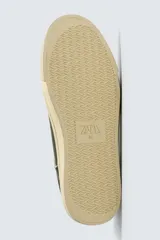 Zapatilla deportiva de estilo retro con diseño de paneles en cuero sintético color verde oscuro, detalles en crema y suela de goma en contraste.