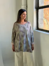 Sweater de punto con diseño animal print difuminado en tonos verdes y grisáceos, de corte holgado, cuello redondo y mangas largas con puños vueltos en color liso.