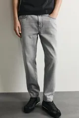Jeans de corte slim cropped confeccionados en denim de algodón rígido con efecto lavado. Presentan tiro medio, cierre frontal con cremallera y botón, y diseño clásico de cinco bolsillos.