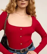 Blusa cropped de punto roja con escote cuadrado, mangas largas y botones dorados.