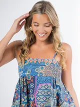 Vestido largo de algodón con estampado multicolor, corte cuadrado y elástico en la espalda. Incluye un aplique de flor desmontable.