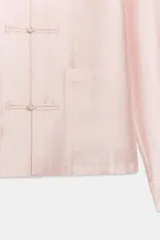 Camisa satinada de manga larga con cuello redondo y cierre frontal con alamares. Cuenta con bolsillos de plastrón en el frente y diseño de corte recto.