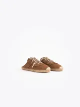 Slide estilo alpargata confeccionado en cuero descarne color celeste, con cordones beige, detalles de flecos y dijes colgantes, sobre una base de yute trenzado.