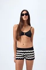 Top de bikini azul con textura fruncida y detalle de aro al frente. Posee breteles finos regulables y un calce cómodo que realza el busto con un toque moderno.