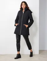 Campera capitoneada de corte largo con diseño de costuras multidireccionales, combinando un patrón de rombos en el cuerpo con capitoneado lineal en laterales y hombros. Cuenta con cierre frontal completo, cuello alto reforzado, capucha desmontable ajustable con cordones y bolsillos laterales con cierre invisible.