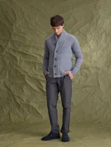 Cardigan de punto gris con cuello tipo chal y cierre frontal de botones. Presenta puños y ruedo acanalados, ofreciendo un diseño clásico y versátil.