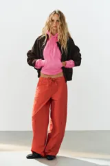 Pantalón cargo oversize de tiro medio color rojo, con bolsillos laterales y de plastrón, y lazadas ajustables en la cintura.