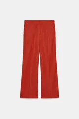 Pantalón de tiro alto color terracota, de tela satinada con textura sutil, corte de pierna ancha y bolsillos delanteros.