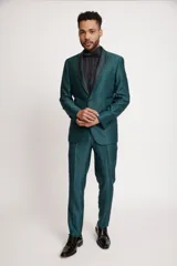 Traje de tres piezas color verde esmeralda con acabado satinado. Incluye saco con solapas en contraste texturizado, chaleco a juego y pantalón de corte slim fit.