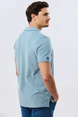 Remera polo piqué de algodón color amarillo, con cuello y puños acanalados, y cierre frontal de botones.