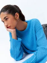 Sweater color crema de tejido de punto acanalado, corte cropped, cuello redondo y mangas largas.