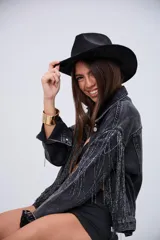 Campera de jean color negro con efecto lavado, de corte oversize, con flecos brillantes integrados en el diseño frontal y en las mangas.