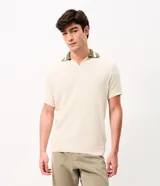 Remera polo de manga corta con textura retilínea, cuello polo en color verde contrastante y apertura frontal. Confeccionada en tejido de poliéster y algodón.