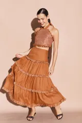 Falda larga negra de lino con volados en distintos niveles, cada uno con un borde brillante.