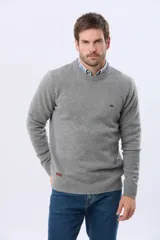 Buzo de lana azul con cuello redondo, manga larga y diseño tejido de punto.